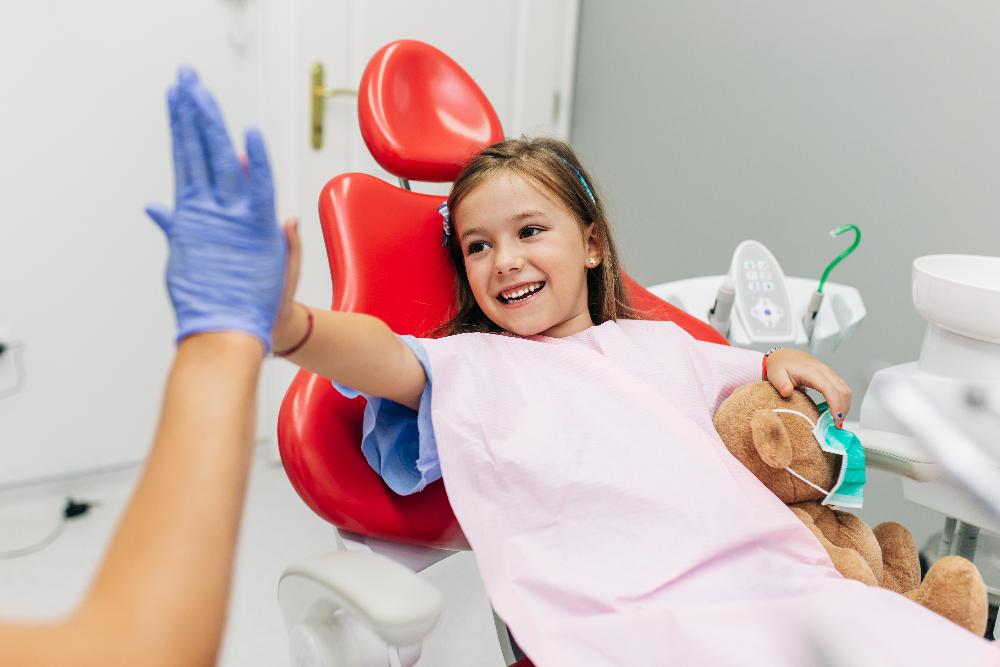child patient high-fiving dentist | pediatric dentist dumbo