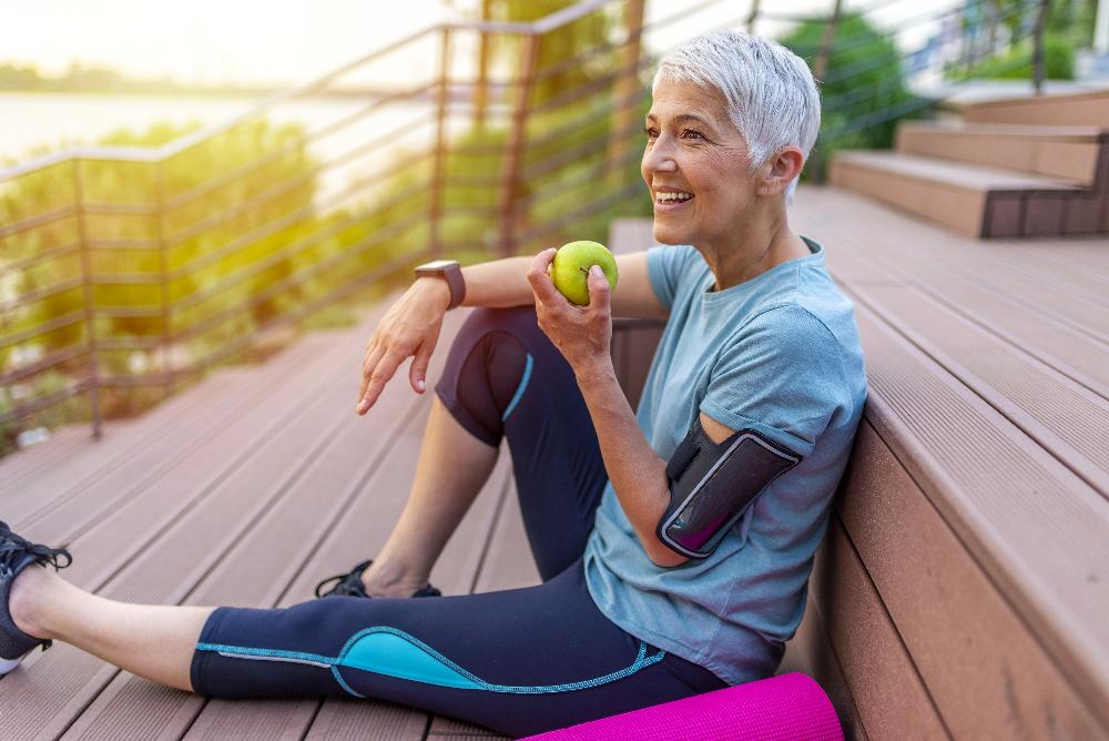 An older woman eating an apple