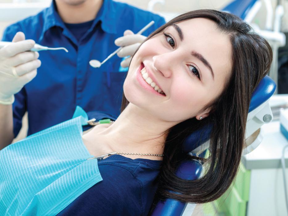 woman smiling in dentist exam chair | dentist brooklyn ny