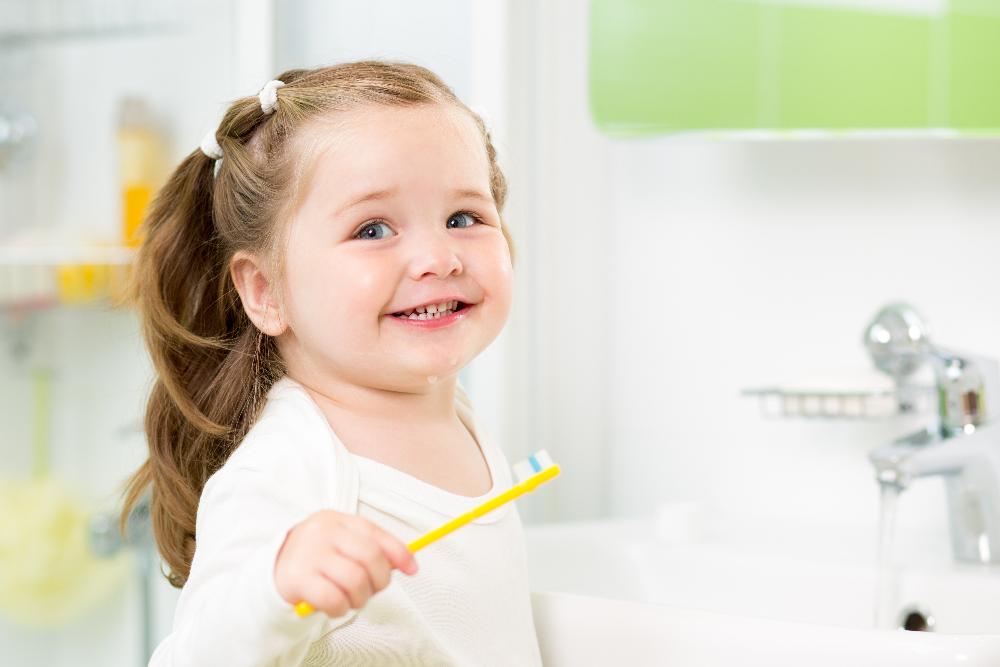 baby girl brushing teeth | pediatric dentist dumbo