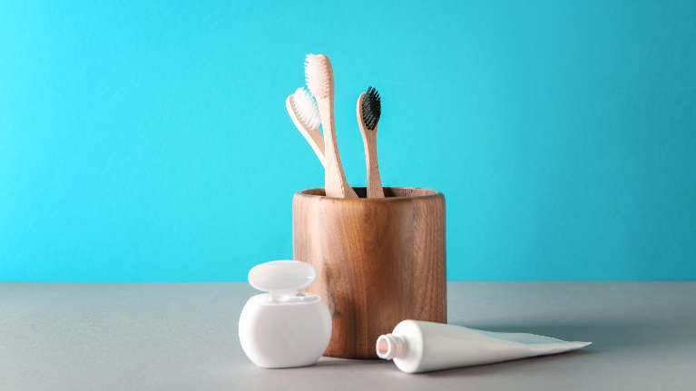toothbrushes in wooden cup | dumbo dental