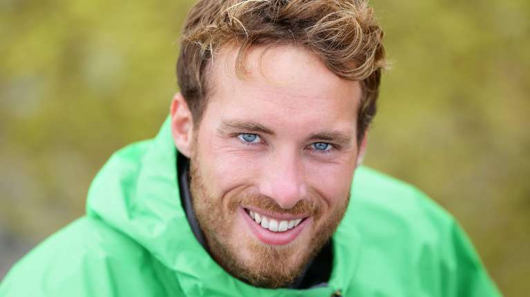 man in green jacket smiling | dental veneers brooklyn