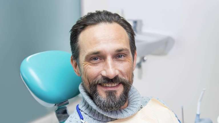 man sitting in dentist chair | dumbo dental care