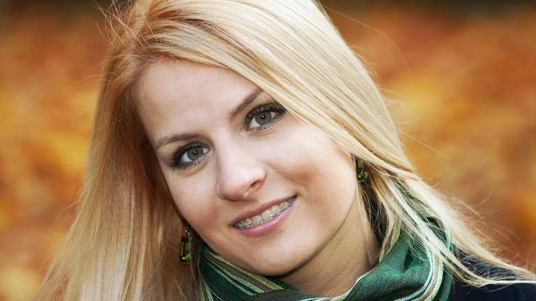 young woman with braces smiling | dentist dumbo heights