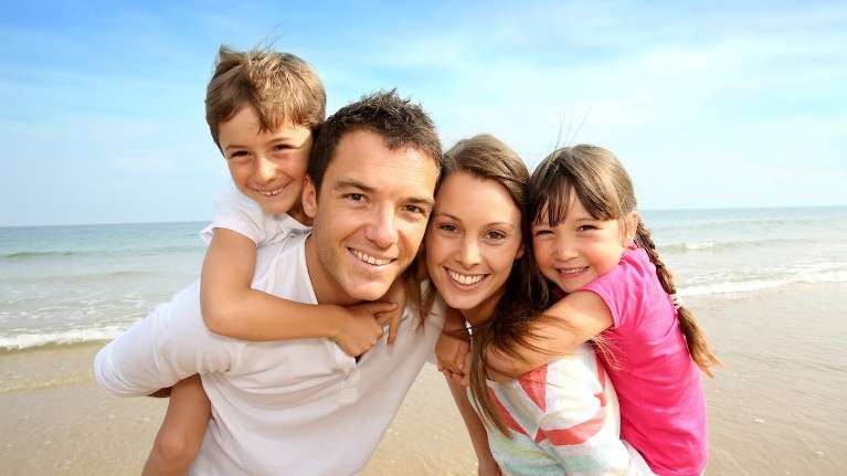 family on beach | dumbo dental care