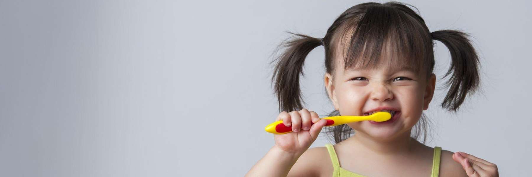 little girl brushing teeth | dumbo dentist office