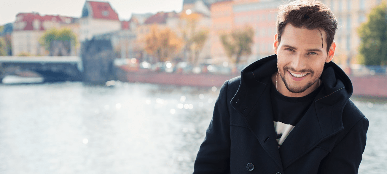 man in black sweatshirt smiling | emergency dentist brooklyn services pc