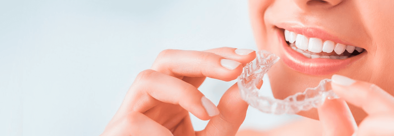 patient putting in clear plastic aligner | invisalign brooklyn