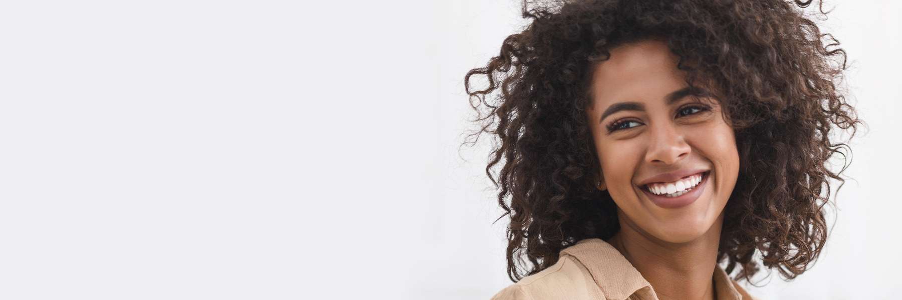 woman with curly hair smiling | dental fillings brooklyn